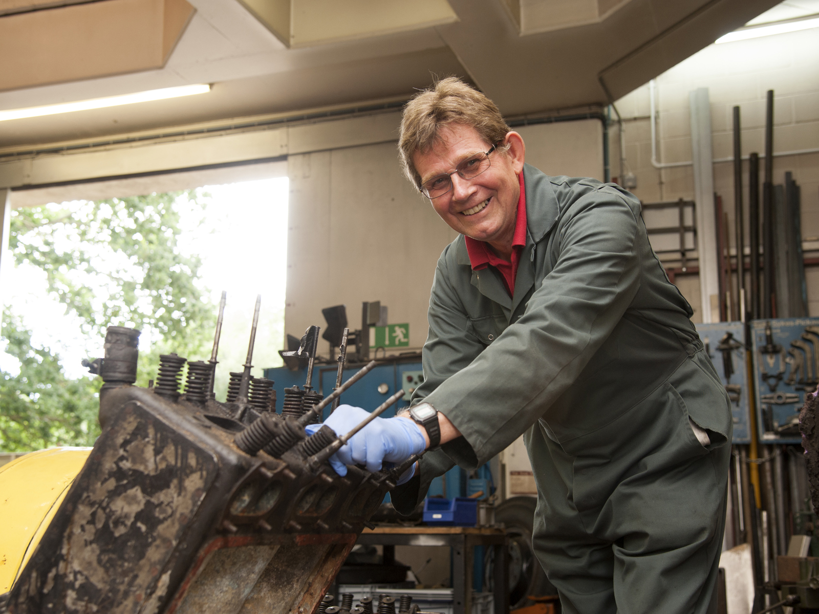 male volunteer working on a car engine