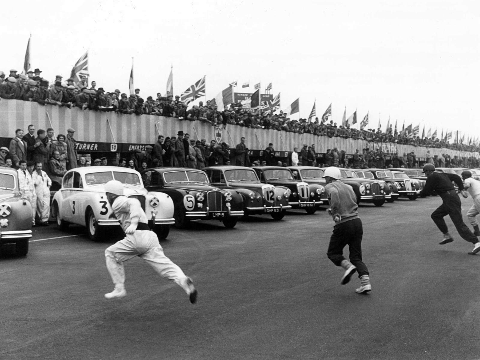 Archive image c1960s of race cars on track with drivers running to their cars