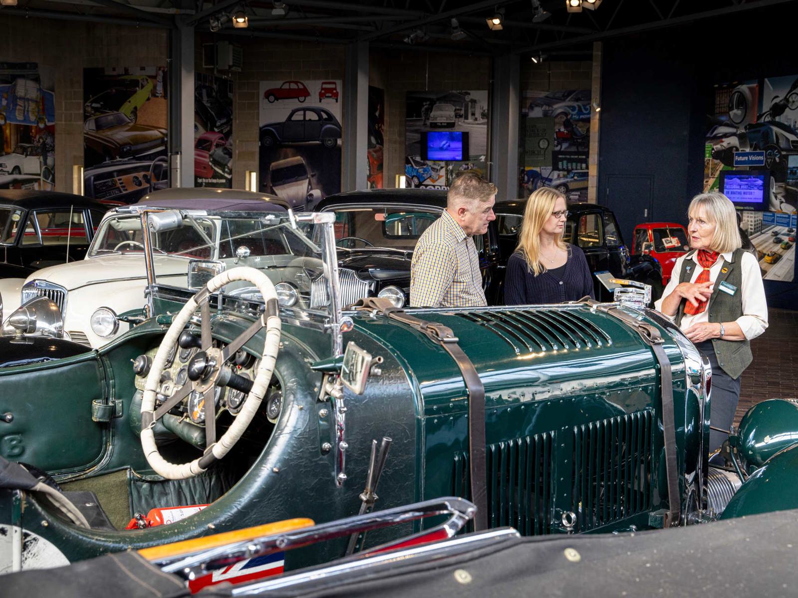 visitors talking to staff in the Driving Change gallery in the National Motor Museum