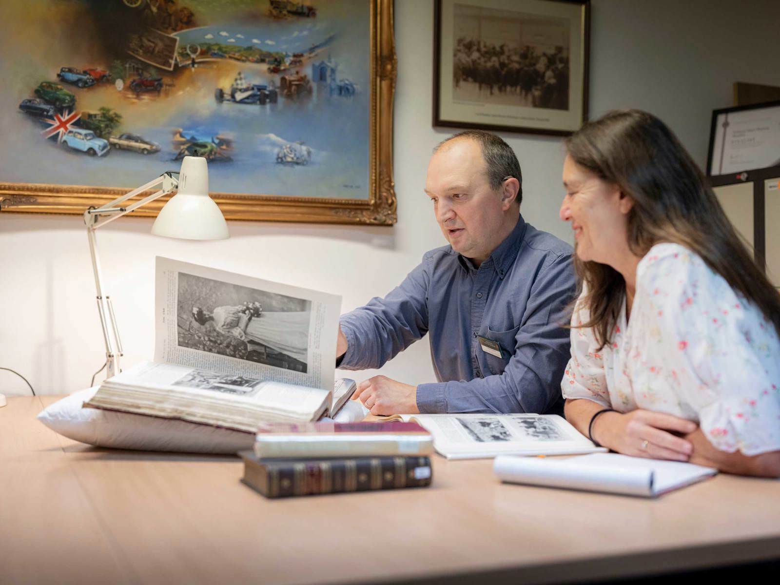 Male and female visitors to the reading room looking at book 