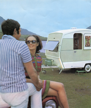 Advert shot of a couple sat by a Sprite caravan