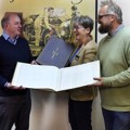 Jon Murden and Andrea Bishop donate record books to Stephen Laing