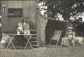 Two women Caravan Club Members seating with their dogs outside the caravan named Santa