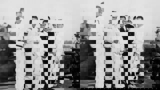 Five mechanics standing in front of Golden Arrow at Daytona Beach, 1929