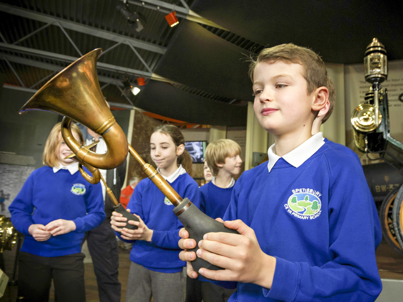 school boy with car horn in the museum