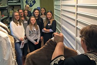 Curator showing a group of students collection items