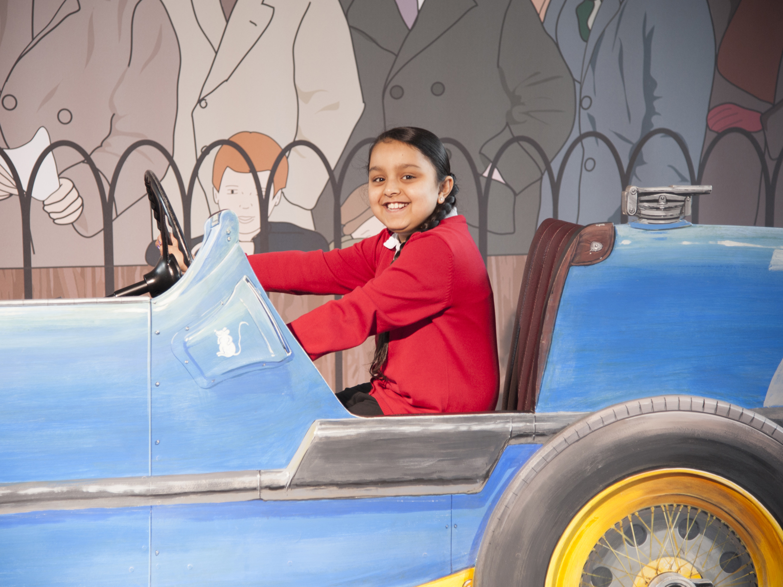 schoolgirl in cut out Sunbeam car having her photo taken