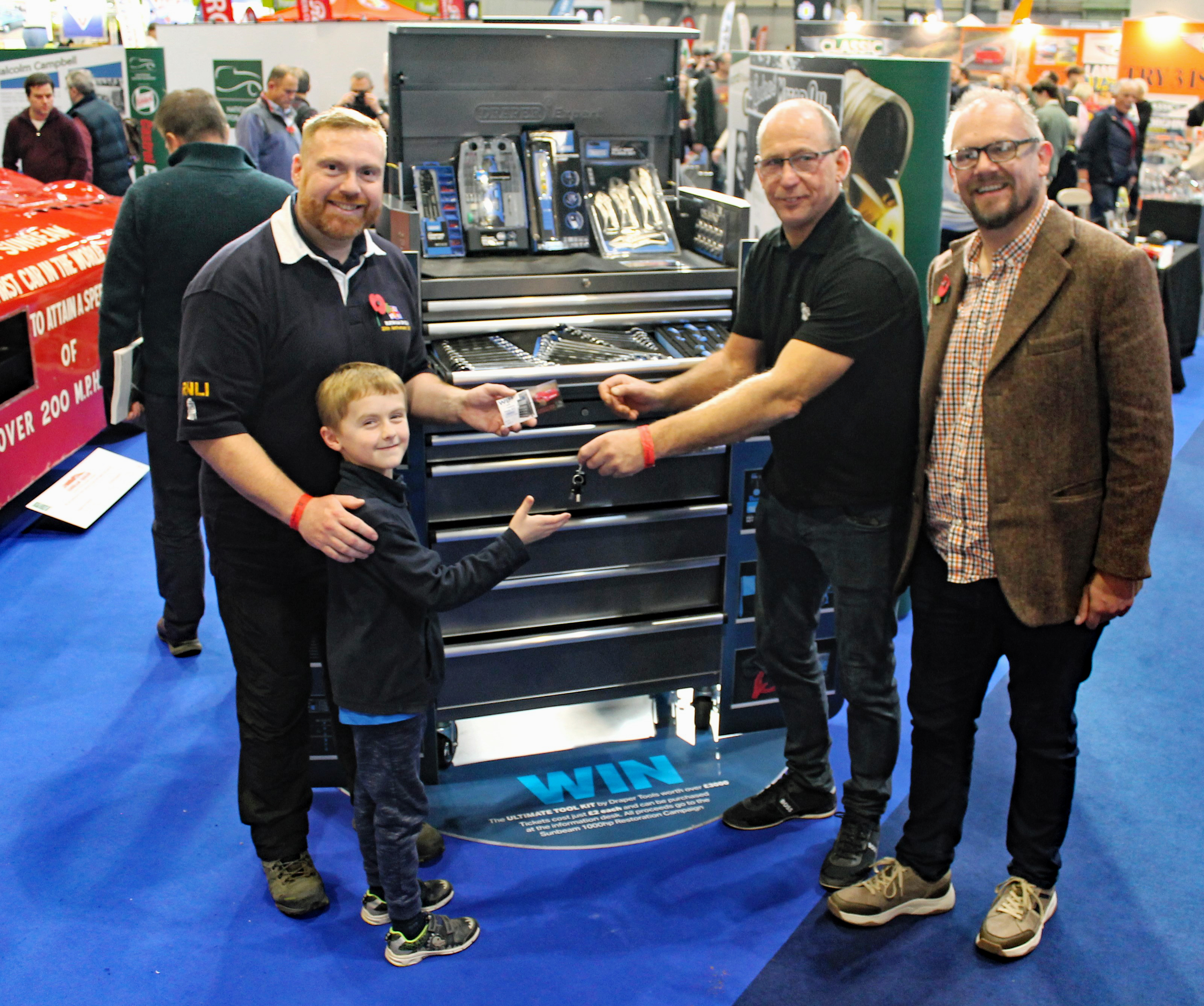 Raffle winner Martin Horton with his son Charlie presented with the Draper Tools toolkit at the Classic Motor Show at Birmingham’s NEC by Jon Murden, Chief Executive of the National Motor Museum and Nigel Whatley, Draper Tools Power Manager.
