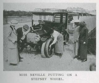 Miss Alice Neville changing a Stepney wheel with 4 people observing her