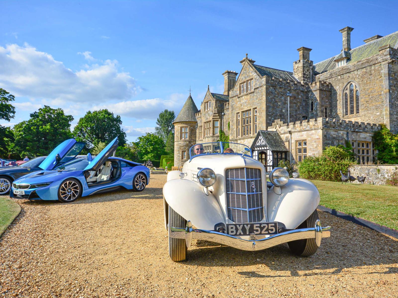 Auburn car outside of Palace House with sports cars in the background