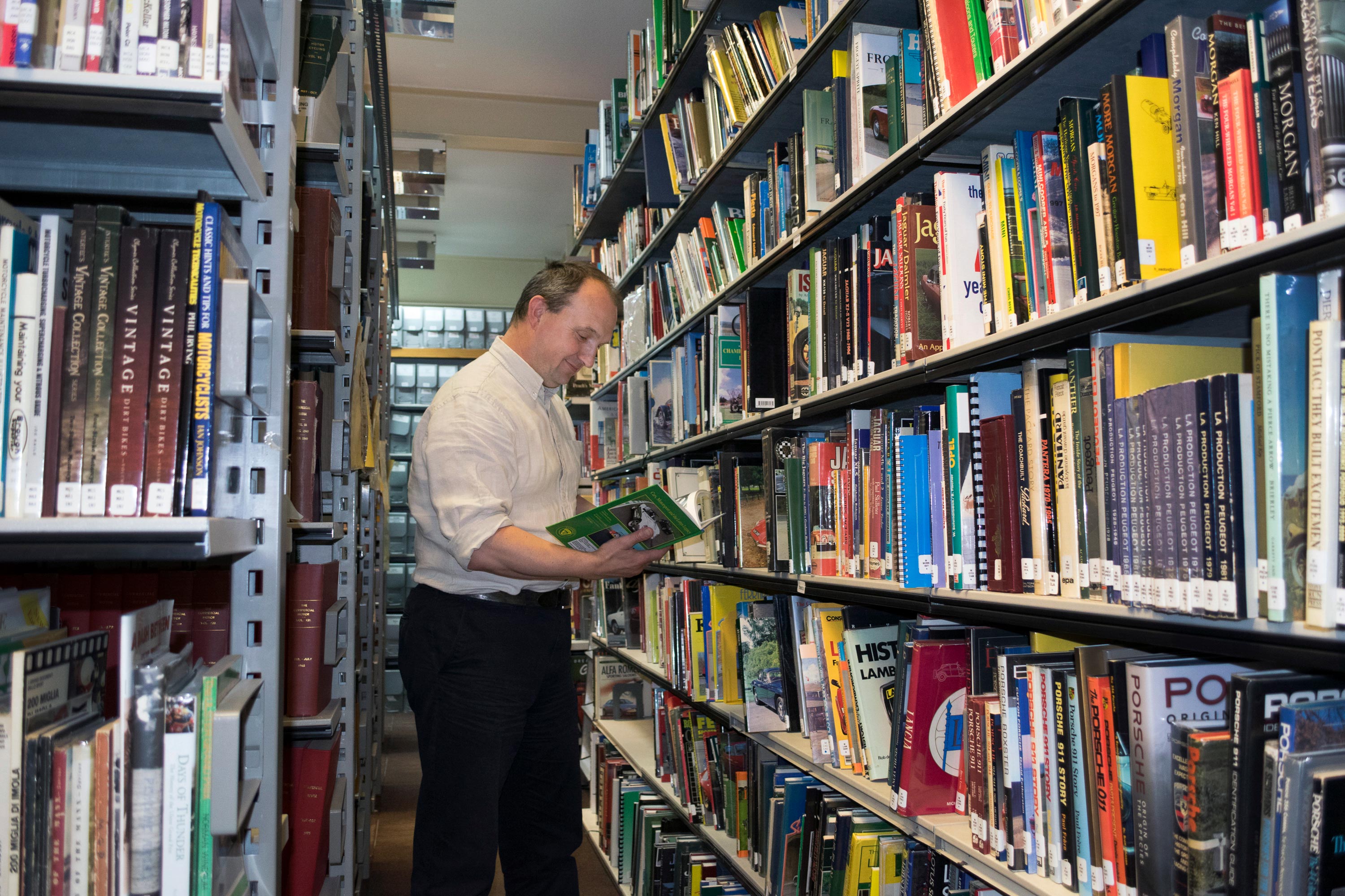 Shelves of books in the reference library with male curator