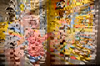 Mother and child look at a case of objects in the Streets Ahead Gallery in the National Motor Museum