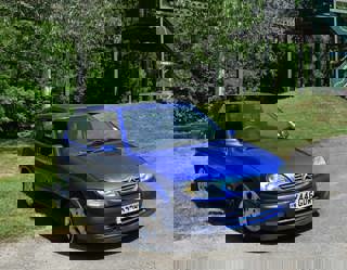 Blue 2000 Citroen Saxo VTS from the Gavin and Stacey BBC series. Pictured in front of the monorail at the National Motor Museum.