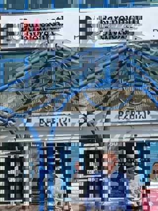 Bournemouth University student standing in front of the uni entrance