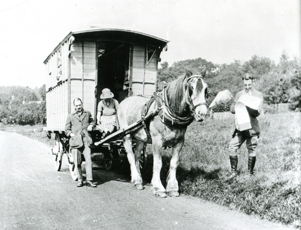 Three people standing with their horse-drawn caravan