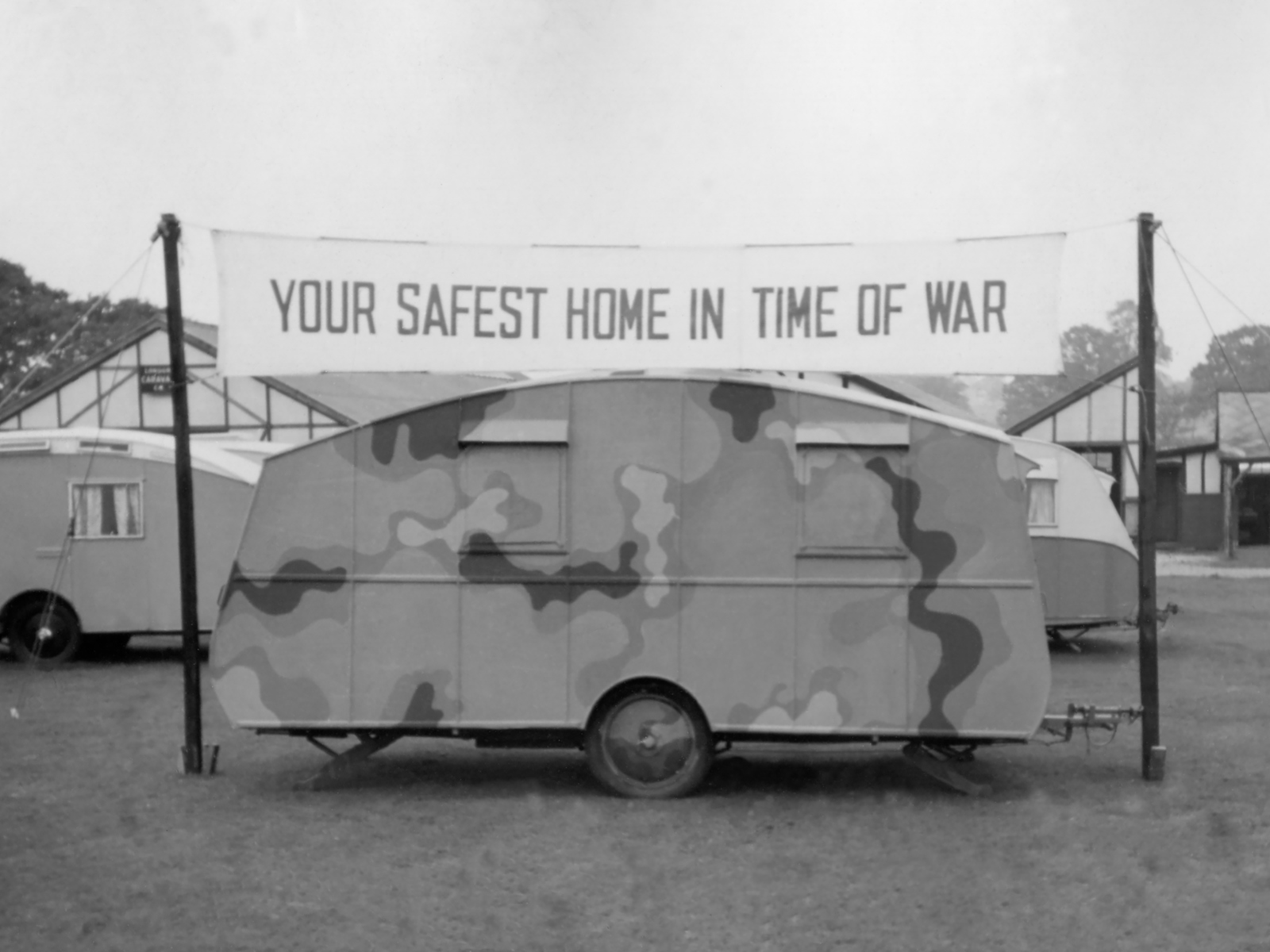 Camouflaged caravan under the banner "Your safest home in war"