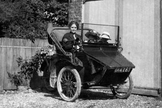 A women and two children sitting in a 1914 AC Sociable