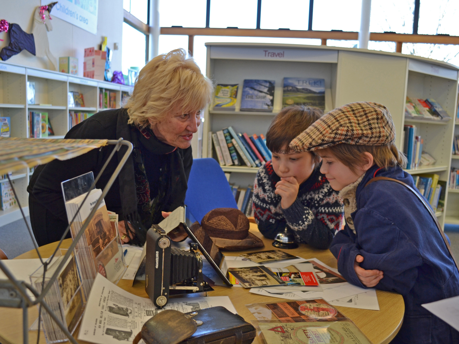 Woman delivering outreach activities to two children in a library