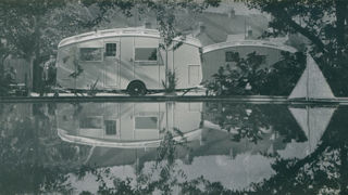 Winchester Royal caravan alongside a boating lake, image is reflected in the water