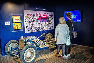 Two people looking at a car at the National Motor Museum