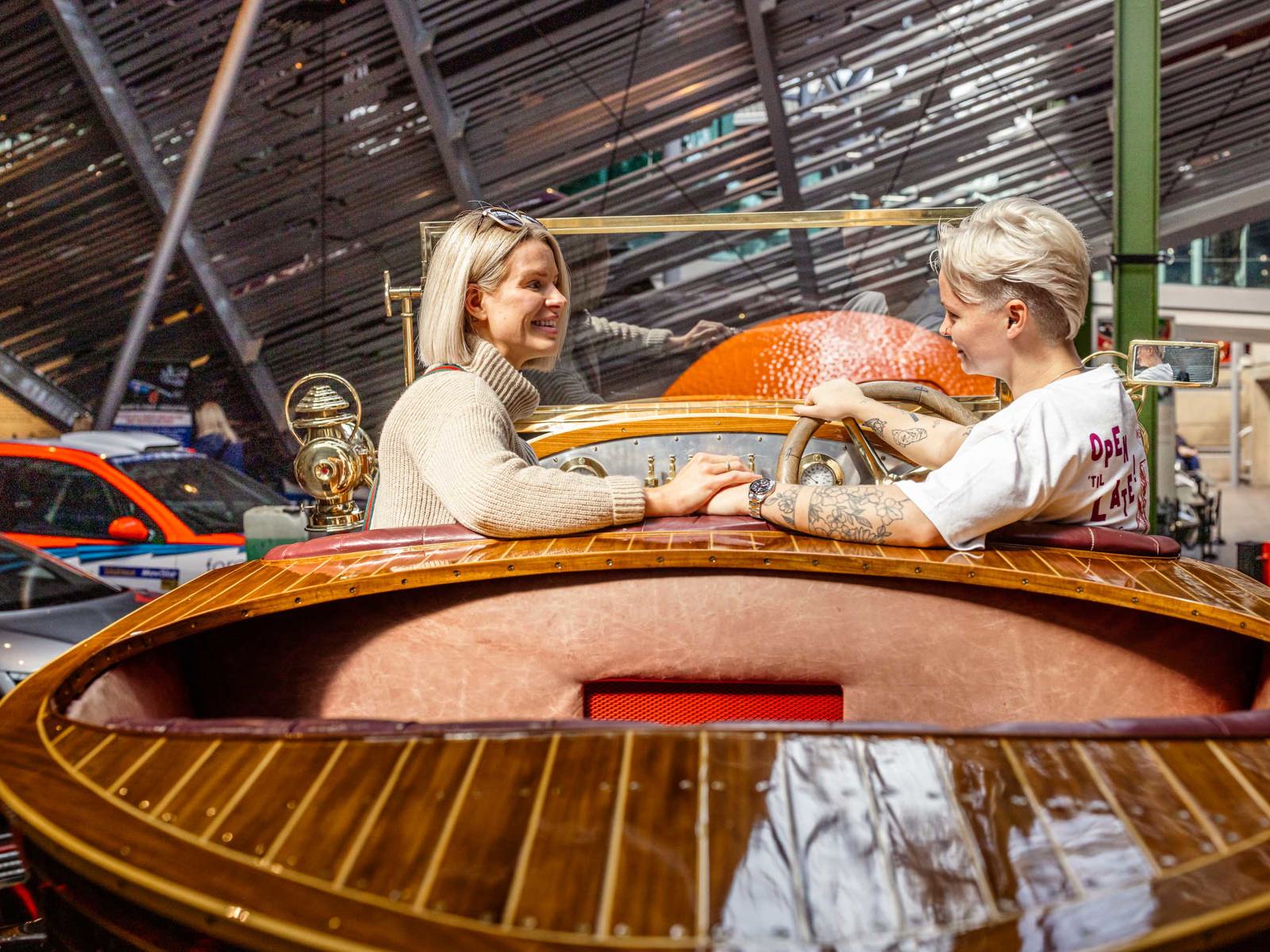 Two female visitors sitting in Chitty car in the National Motor Museum