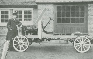 Mrs Herbert Lloyd standing by the car chassis she designed for a Daimler engine