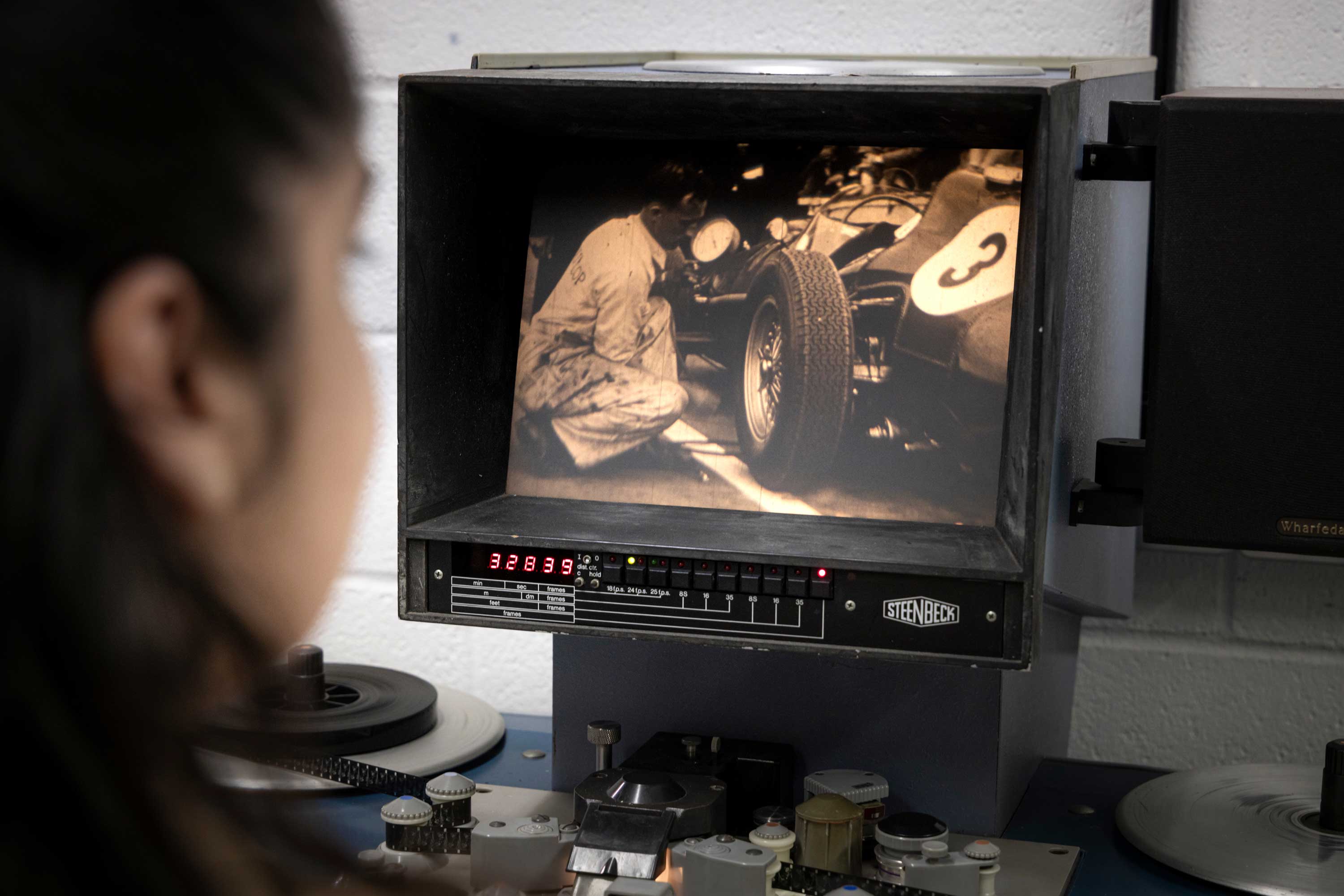 female member of staff viewing archive film on a Steenbeck machine