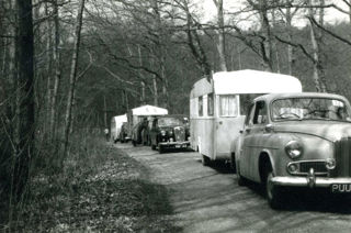 Car and caravan outfits lined up on the road section at a late 1950s Caravan Road Rally.