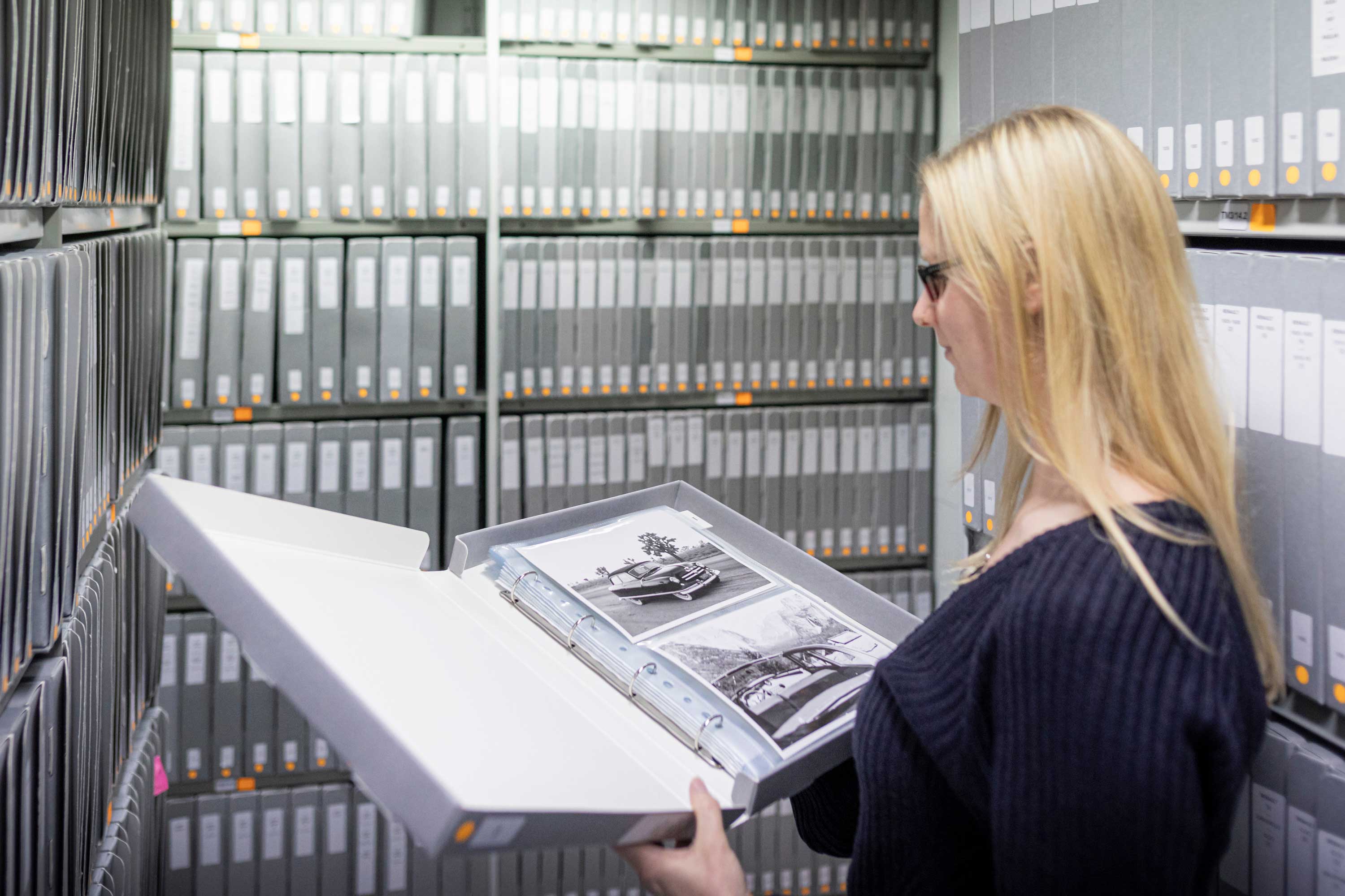 lady looking at photograph album with shelving in background