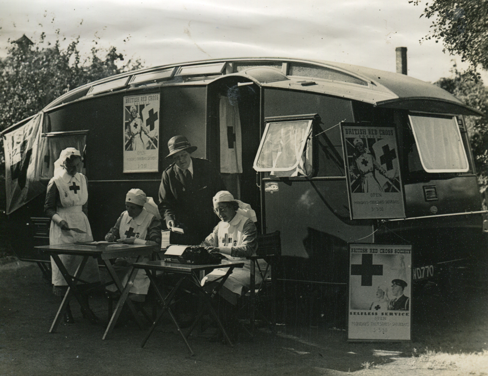 Mrs Fowler and other Red Cross nurses in front of one of her blue caravans